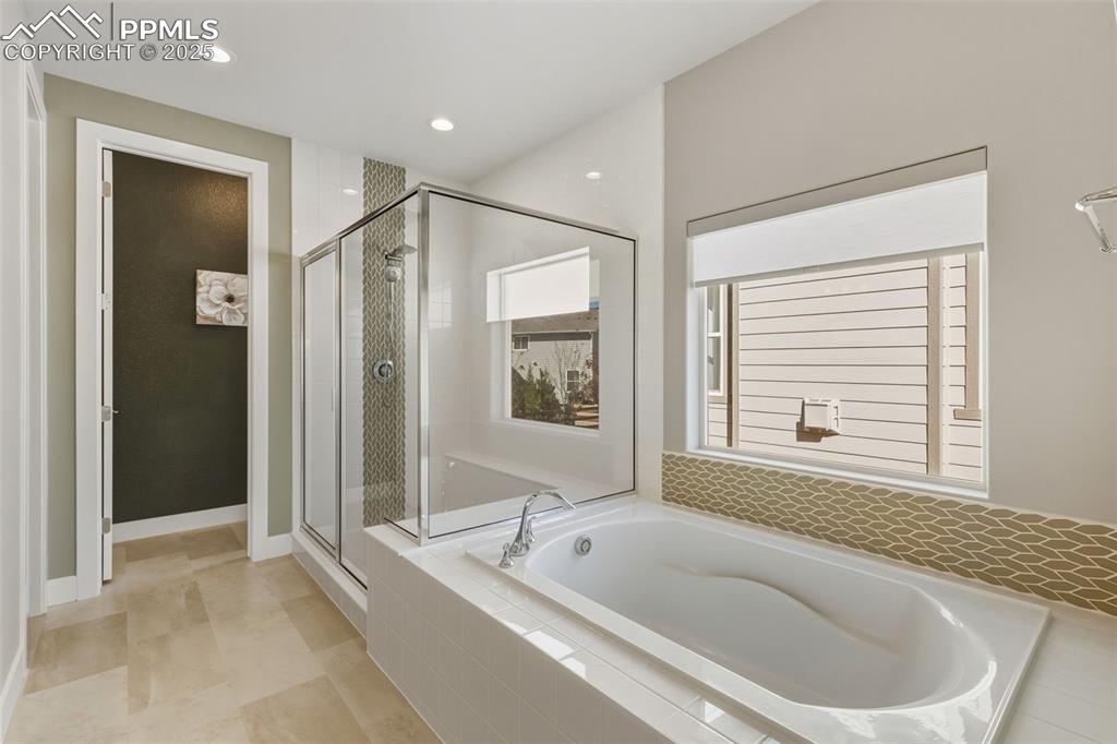 Full bathroom featuring a garden tub, a stall shower, recessed lighting, and light tile patterned flooring