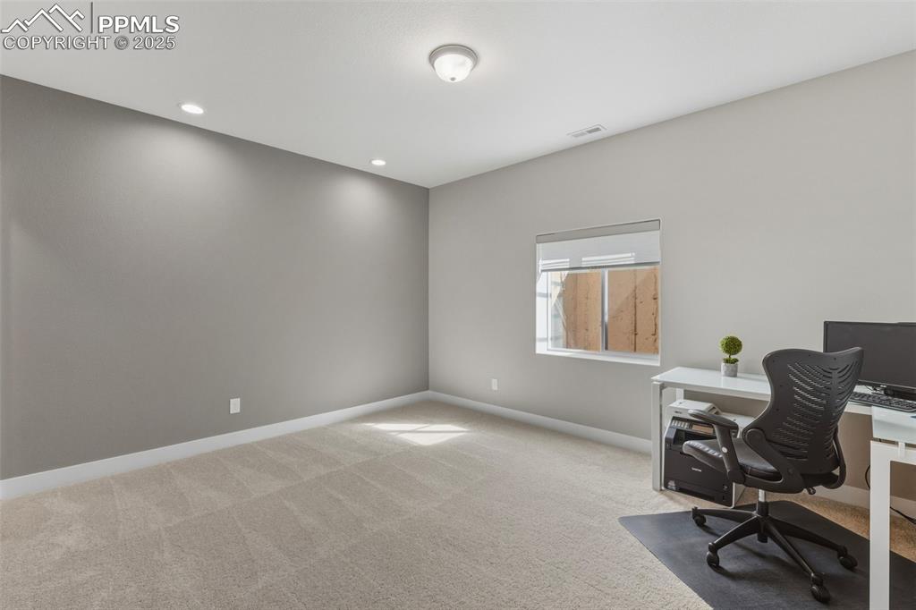 Office space featuring light colored carpet and recessed lighting