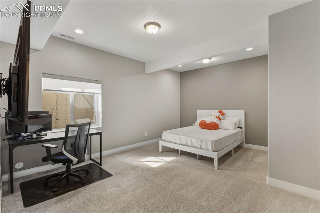 Bedroom featuring light colored carpet, recessed lighting, an office area, and beamed ceiling