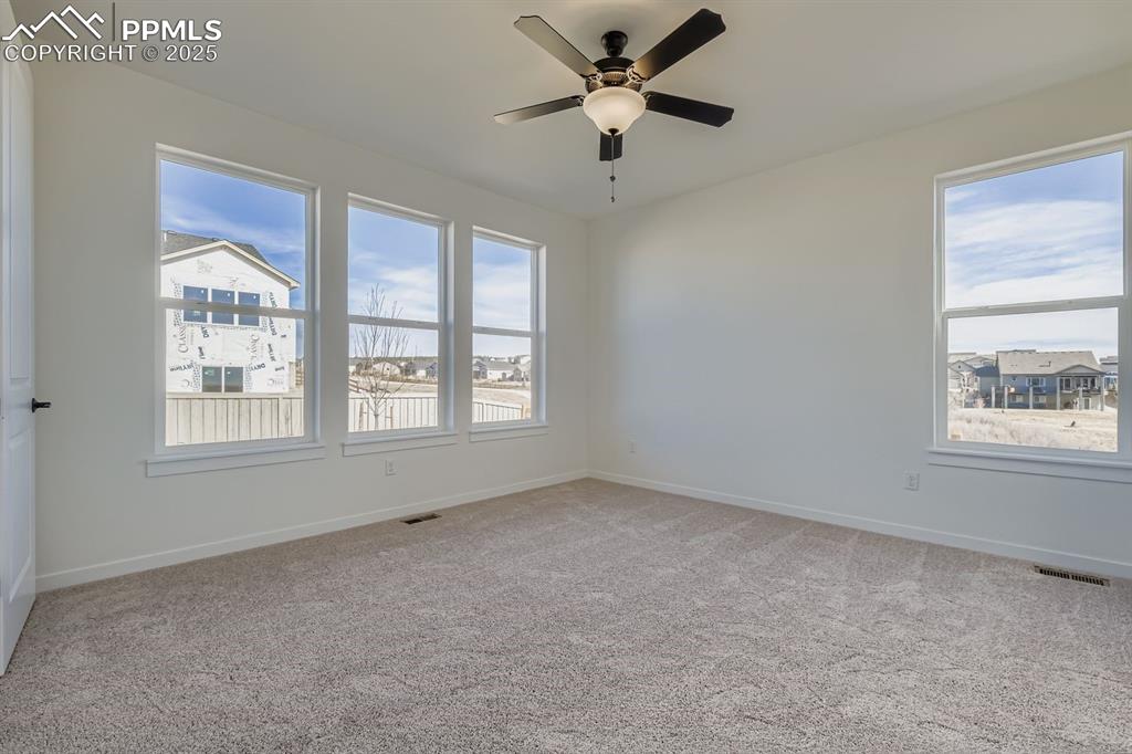 Spare room with light colored carpet and a ceiling fan