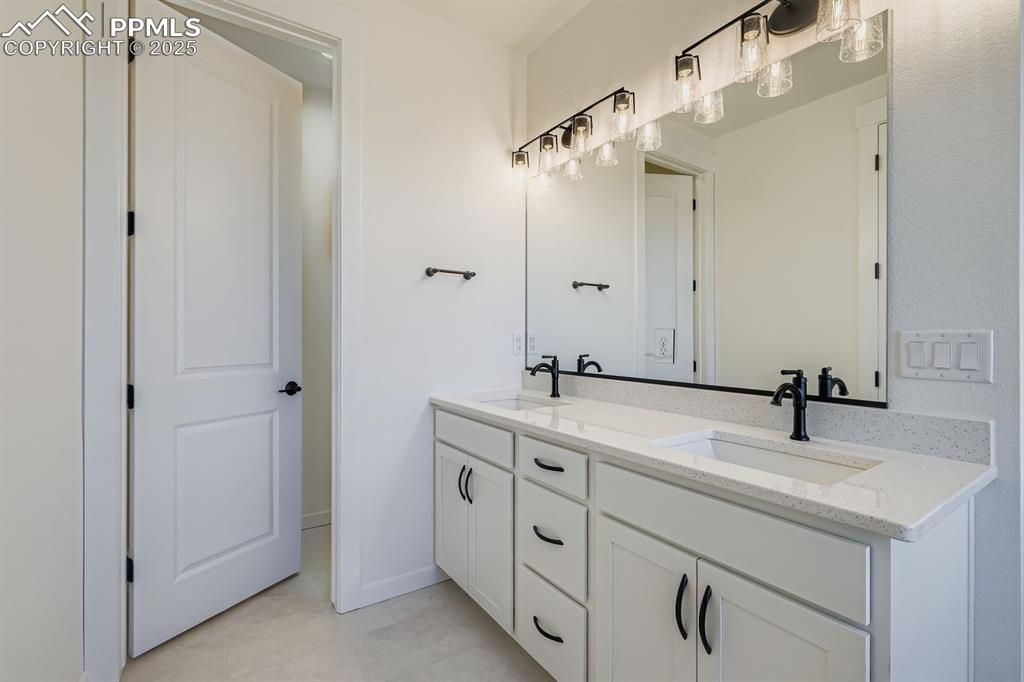Bathroom featuring double vanity and light tile patterned floors