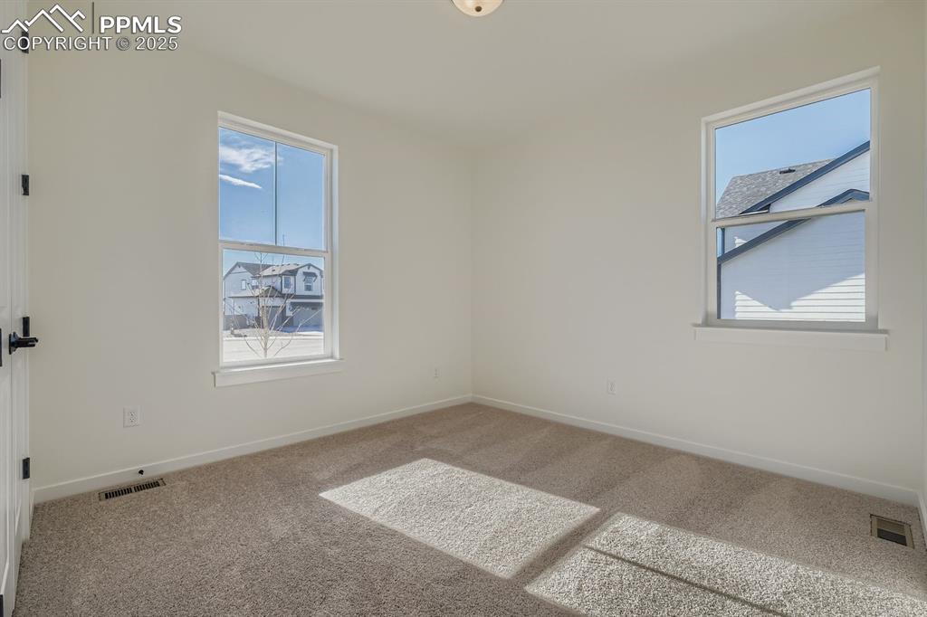 Carpeted spare room with baseboards
