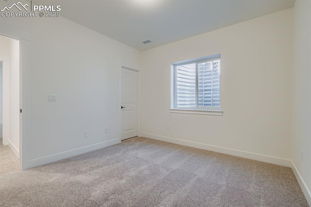 Spare room featuring light colored carpet and baseboards