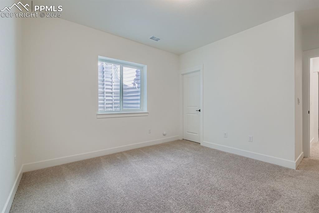 Spare room featuring baseboards and light carpet