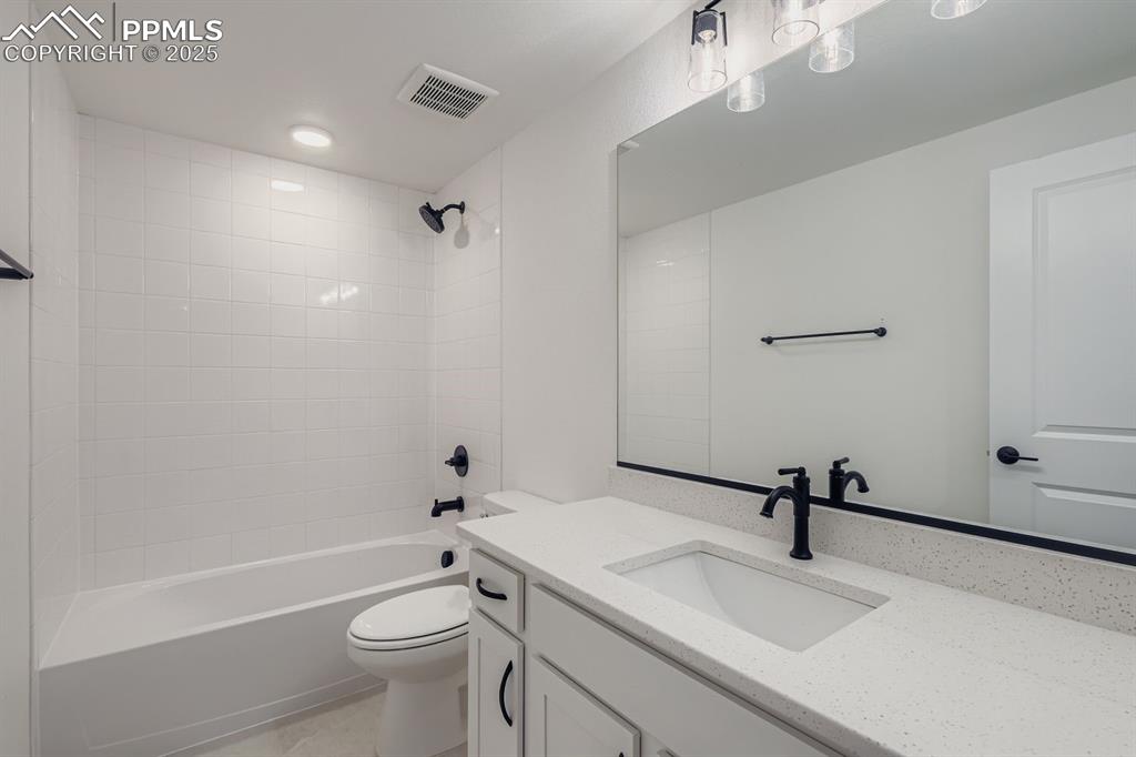 Bathroom featuring shower / washtub combination, vanity, and light tile patterned floors