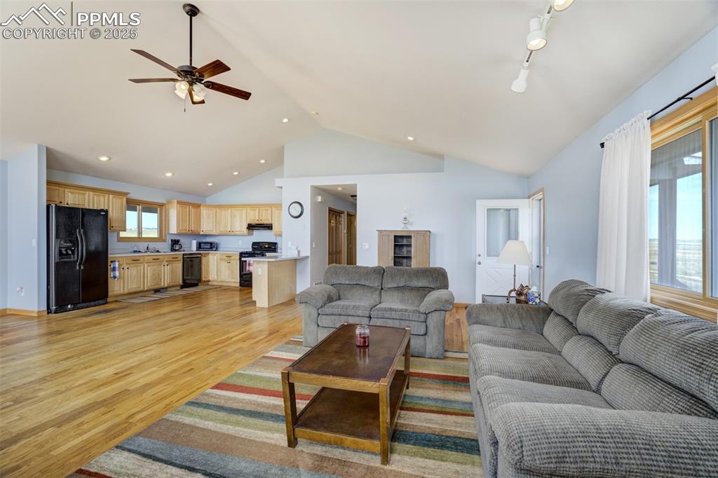 Living room featuring ceiling fan, light wood finished floors, high vaulted ceiling, and recessed lighting