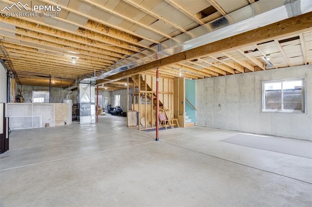 Below grade area with heating unit, water heater, and stairway