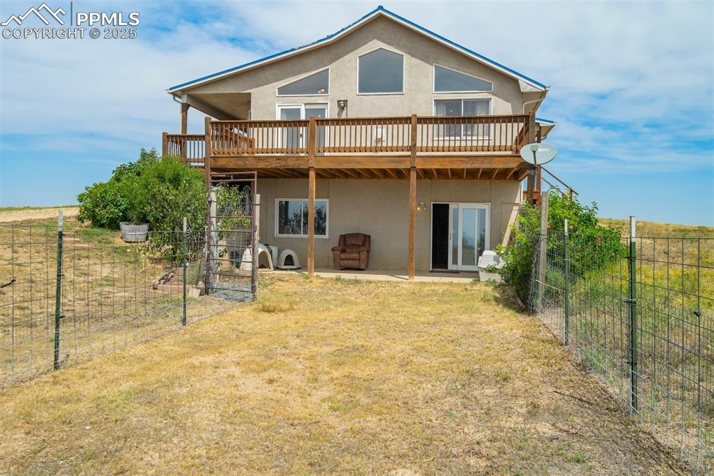 Back of property featuring stucco siding, a deck, and a patio area