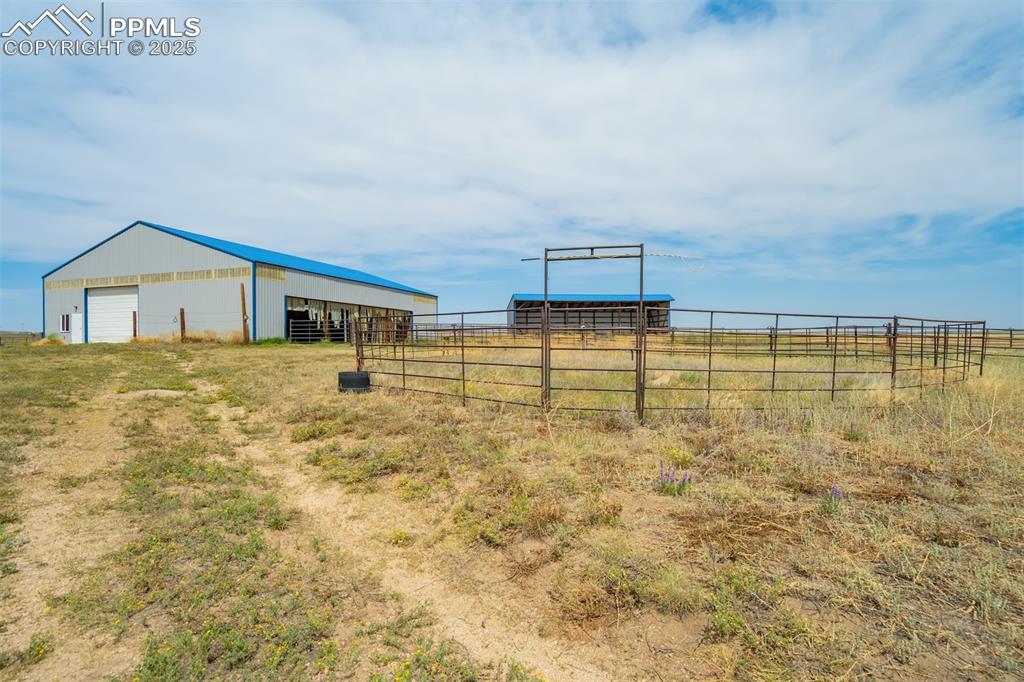 View of yard featuring a pole building, an outdoor structure, and a rural view