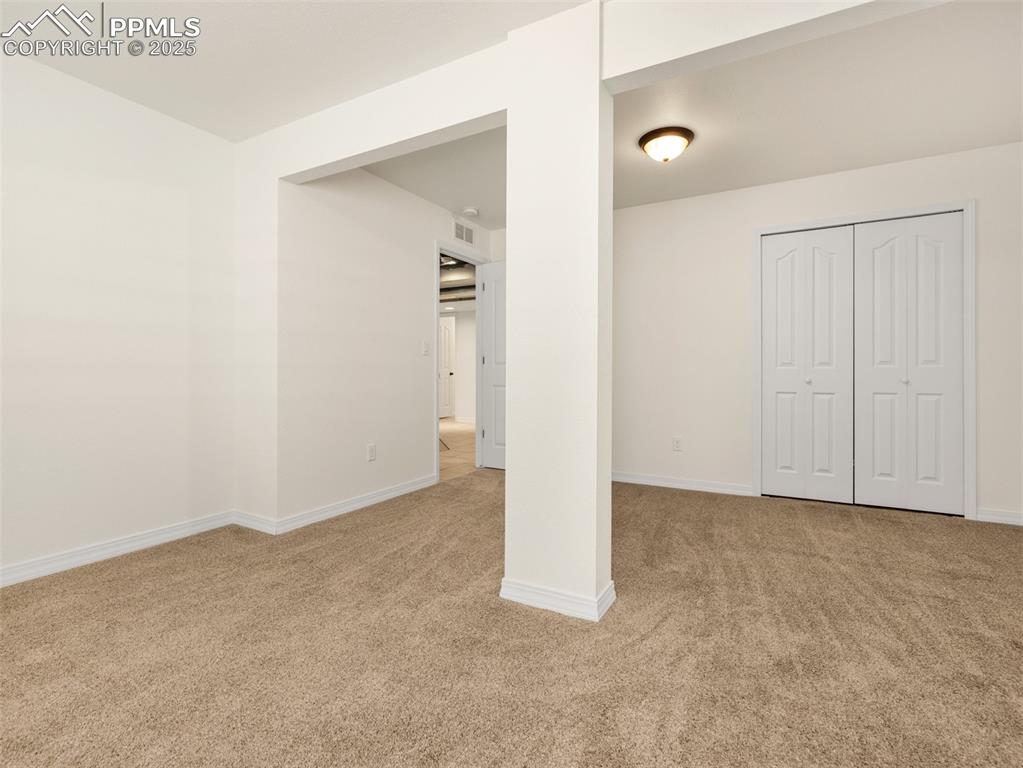 Unfurnished bedroom with light carpet and a closet