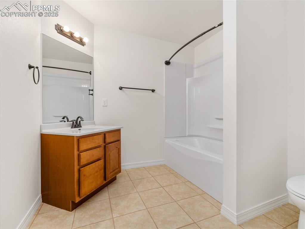 Bathroom with vanity, shower / tub combination, and tile patterned floors