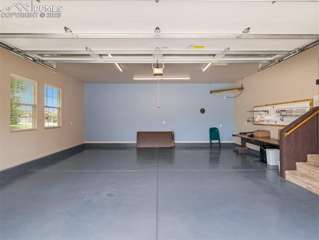Garage with a garage door opener and baseboards