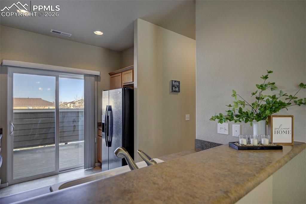 Balcony leading from kitchen to 2 person spa and mountain views.