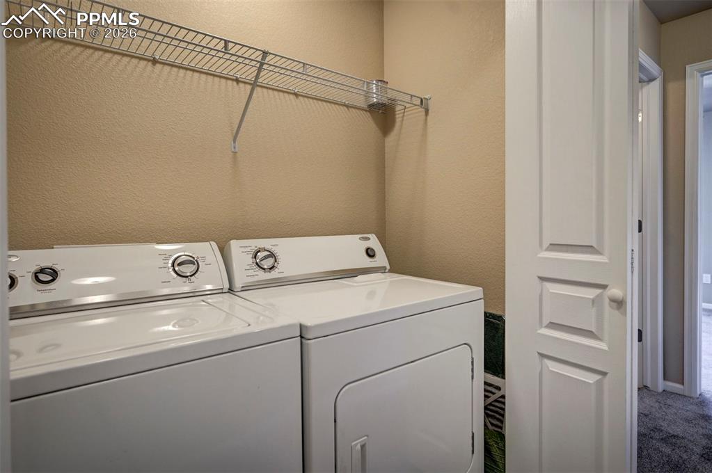 Whirlpool washer and dryer conveniently located between primary and secondary bedrooms.
