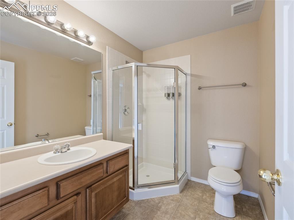 Bathroom with a stall shower, vanity, and light tile patterned floors