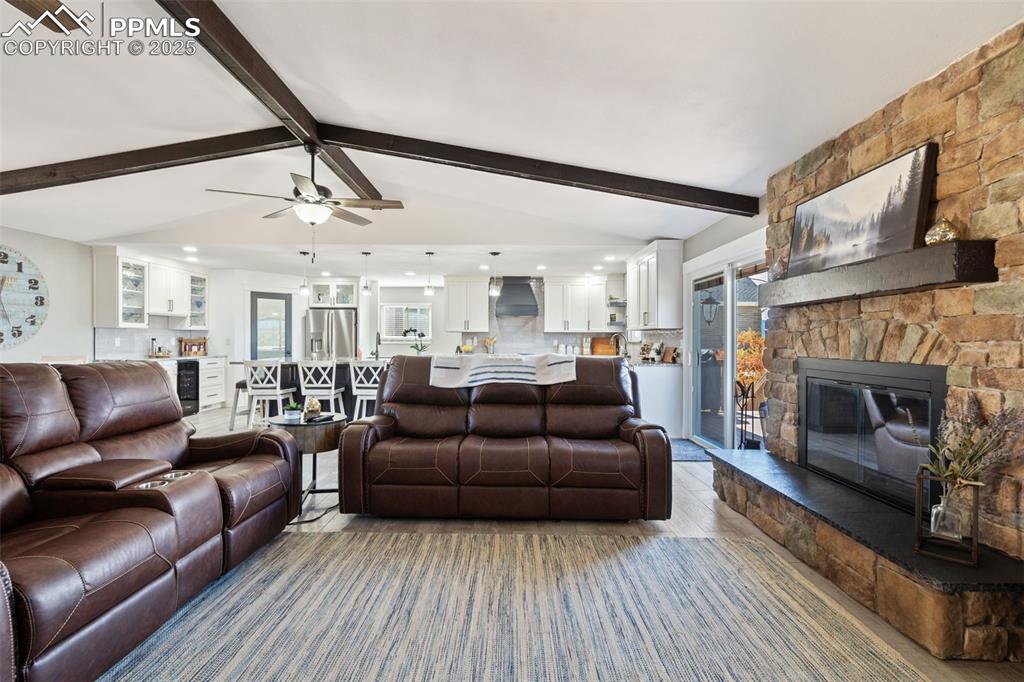 Cozy open living room with a vaulted beam ceiling, stone wood-burning fireplace - amazing entertaining space!