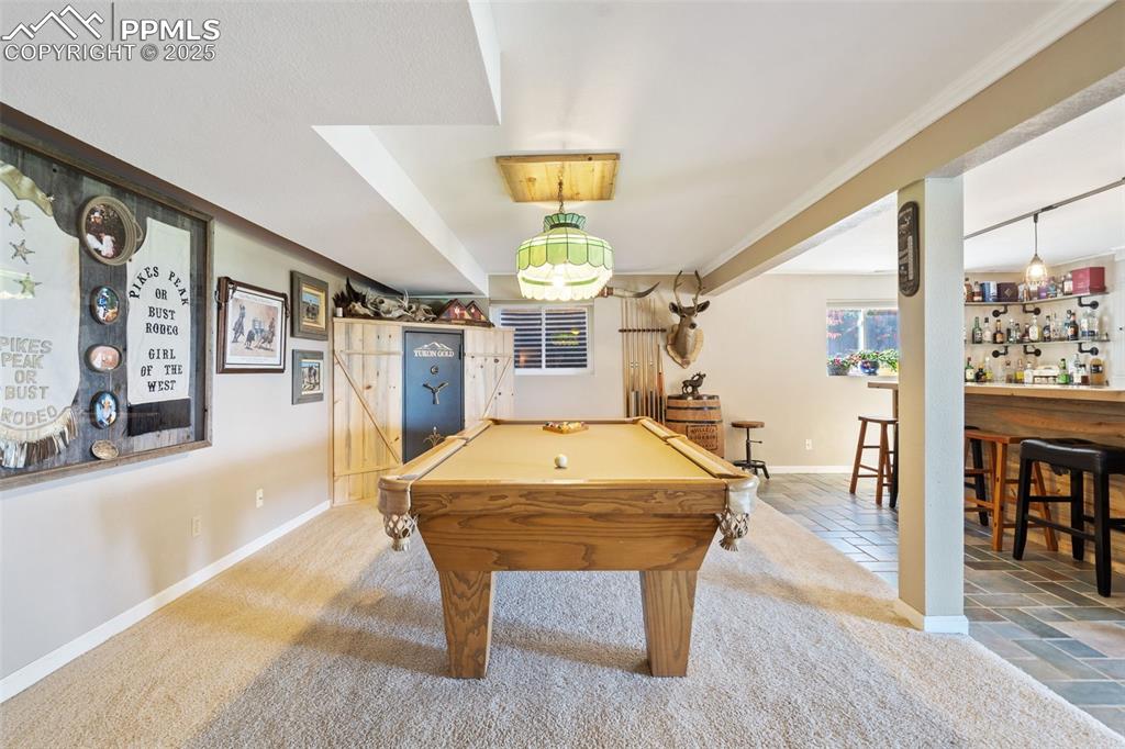 Beautiful pool table compliments this space perfectly! It stays along with the built-in corner gun safe.