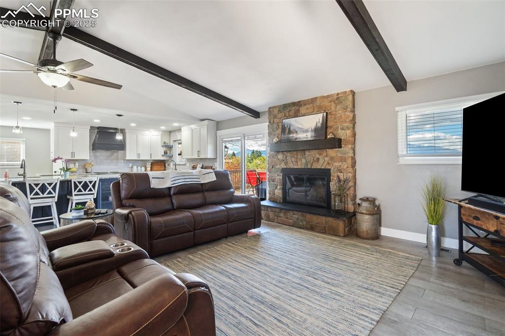 Open concept floor plan with vaulted beamed ceilings, wood-burning stone fireplace, and walk-out to beautiful composite deck. Remodeled in 2024 and gorgeous!!