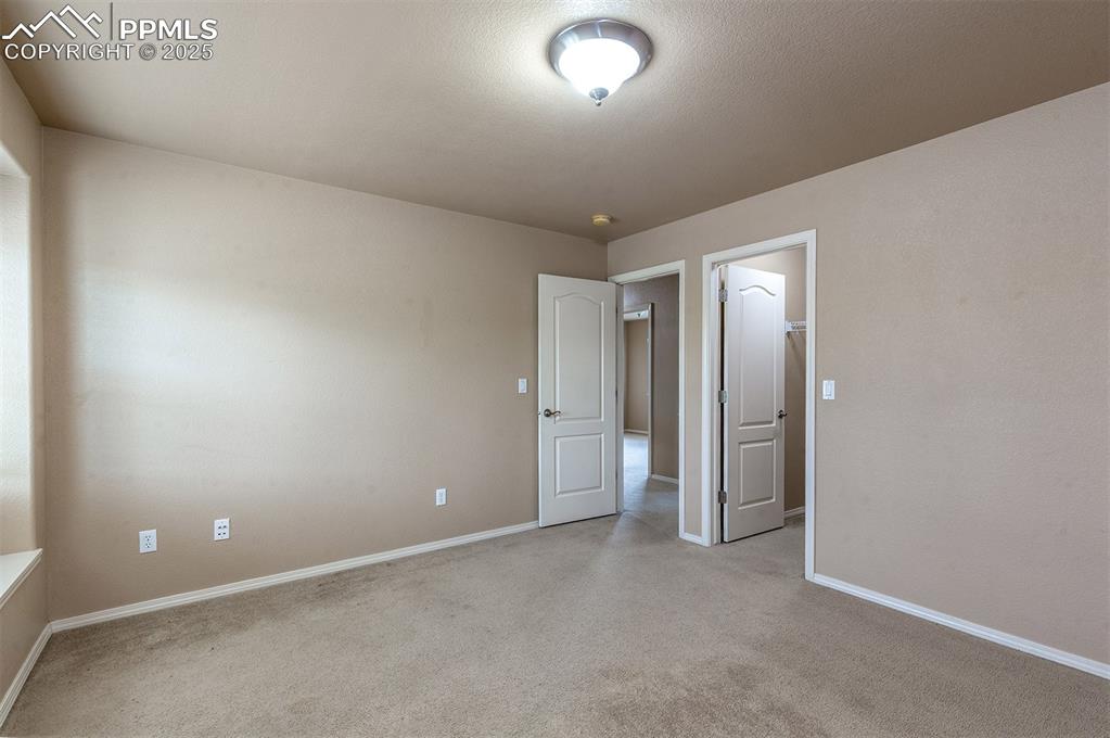 Spare room featuring light carpet and a smoke detector