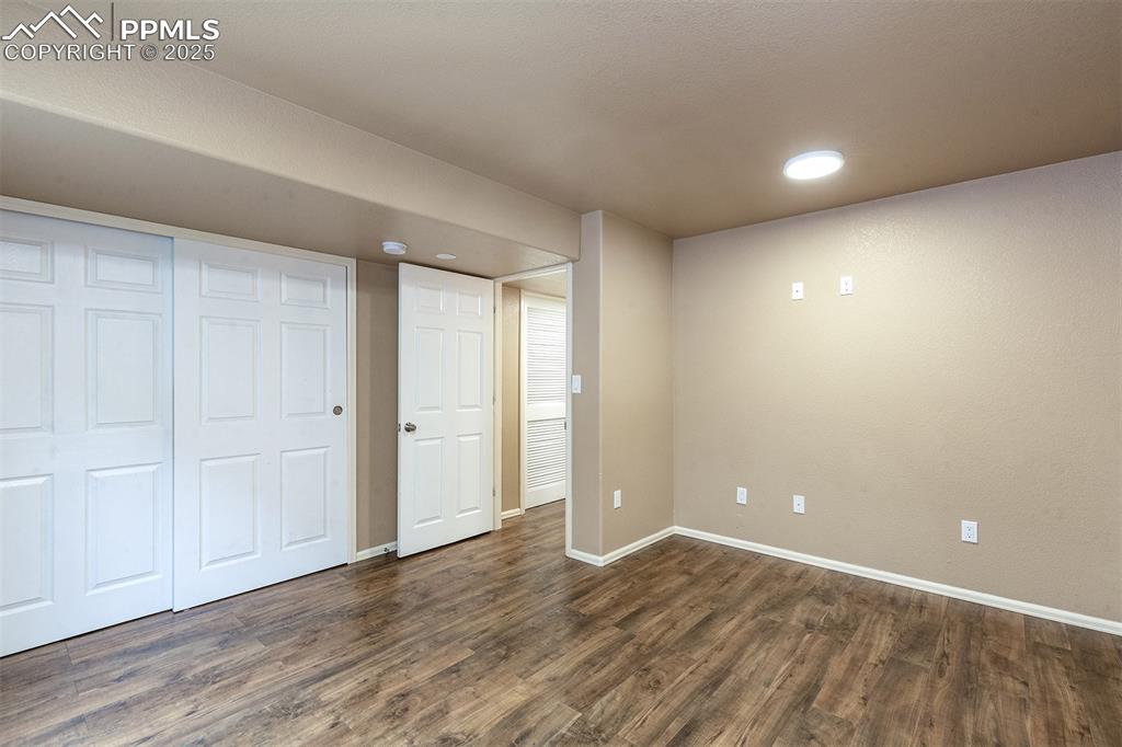 Unfurnished bedroom featuring dark wood-style flooring, recessed lighting, and a closet