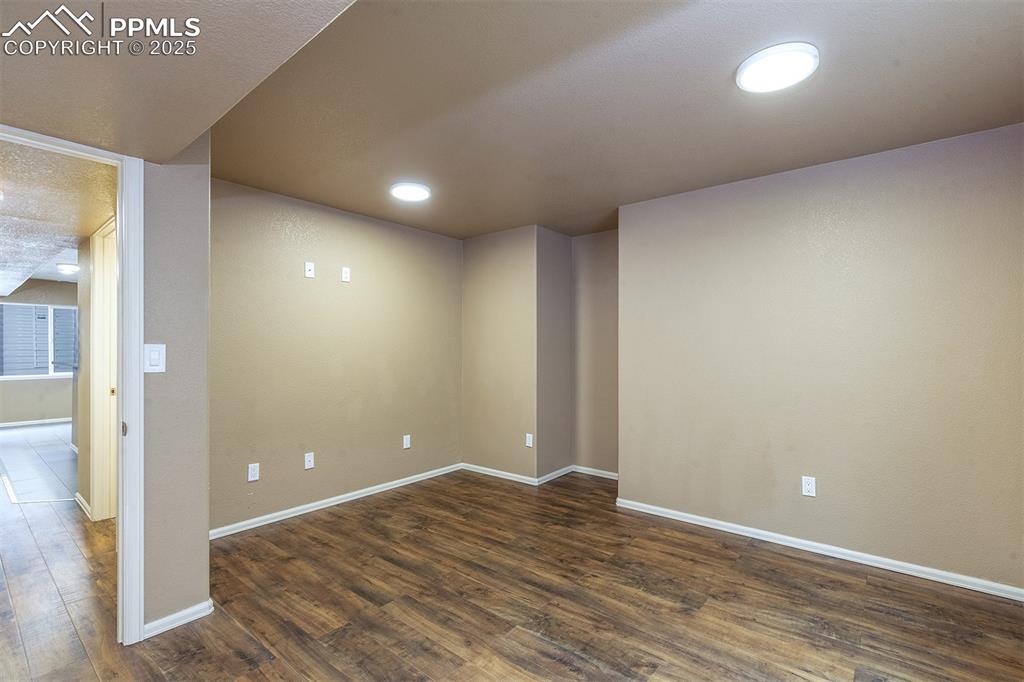 Below grade area featuring dark wood-type flooring and baseboards