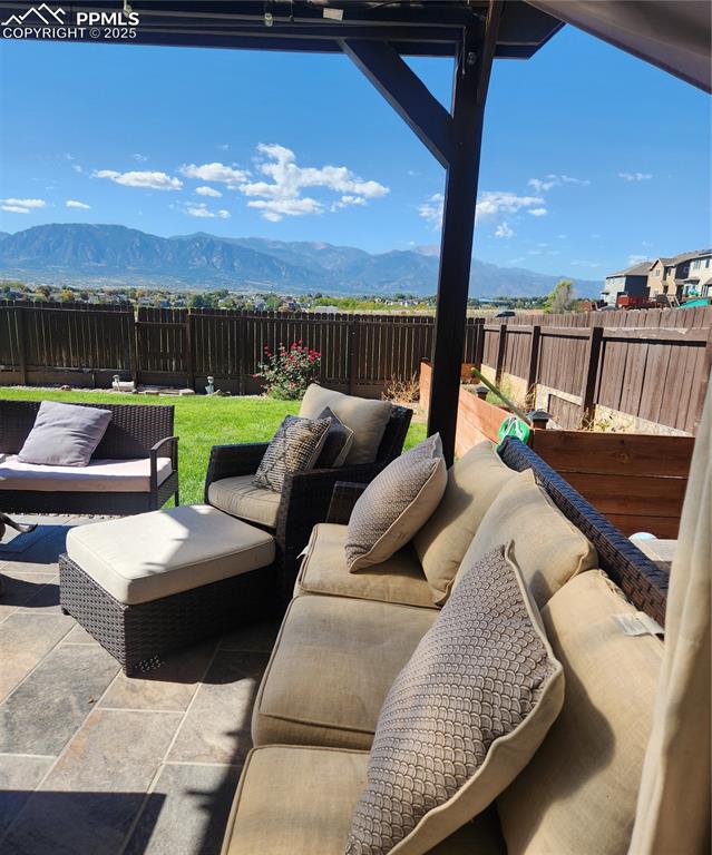 Fenced backyard with a mountain view, a patio area, and outdoor lounge area