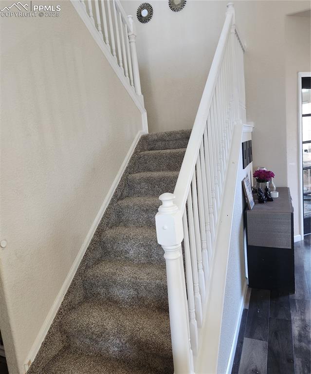 Stairs featuring baseboards and carpet floors