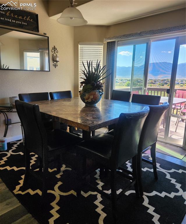 Dining area featuring a mountain view and a textured wall
