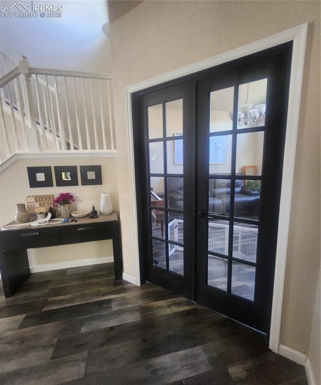 Entryway featuring wood finished floors, stairway, and french doors