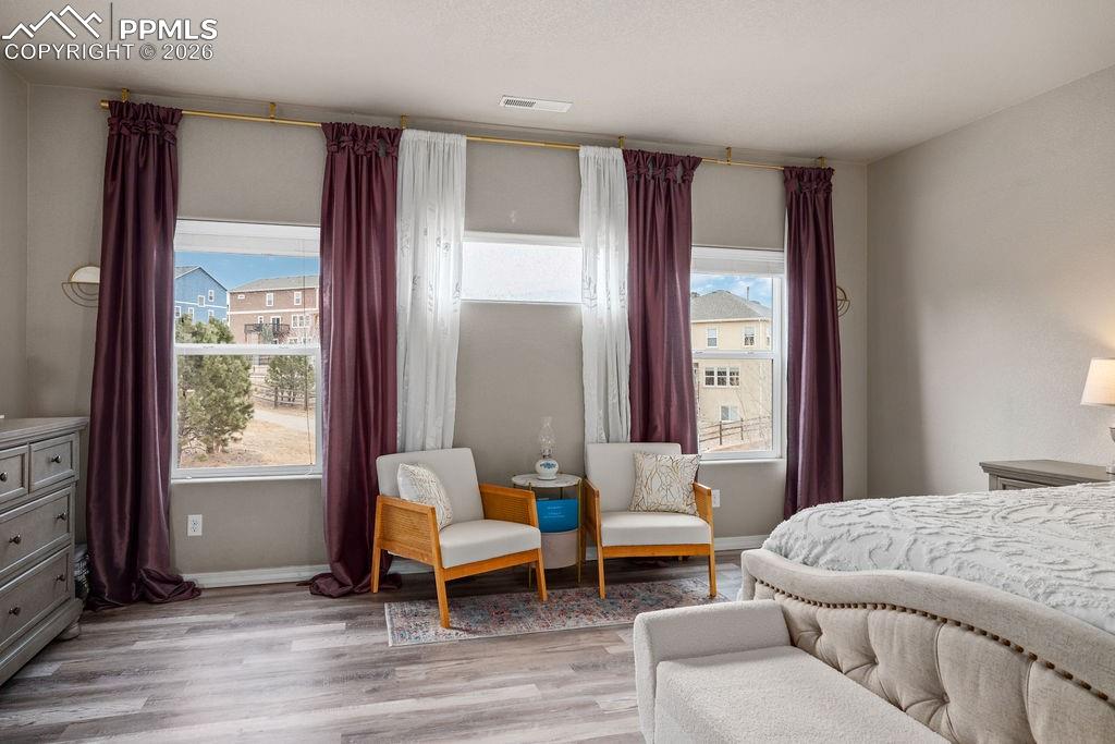 Upper floor primary bedroom featuring light wood-style flooring and baseboards