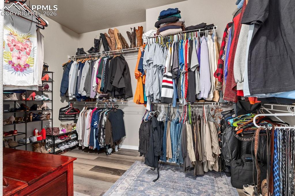 Walk in closet with light wood-style floors