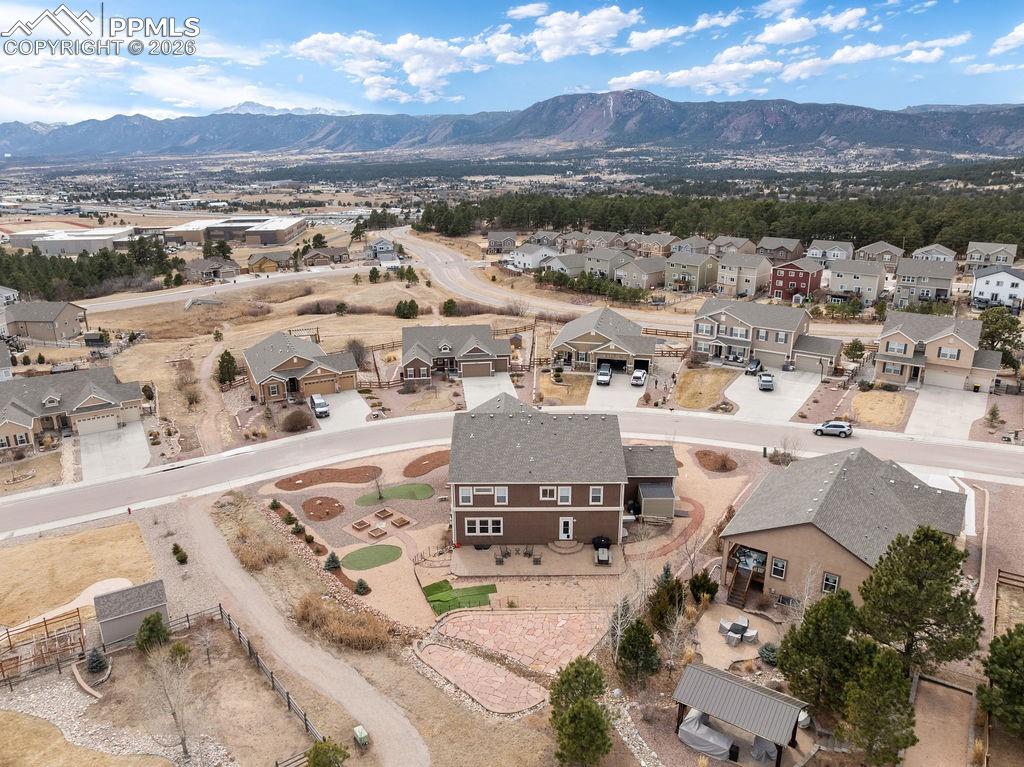 Aerial view of property and surrounding area featuring a mountainous background and nearby suburban area