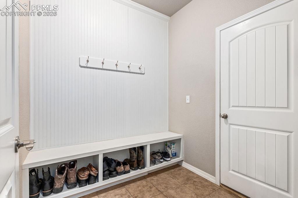 Mudroom featuring light tile patterned flooring and baseboards