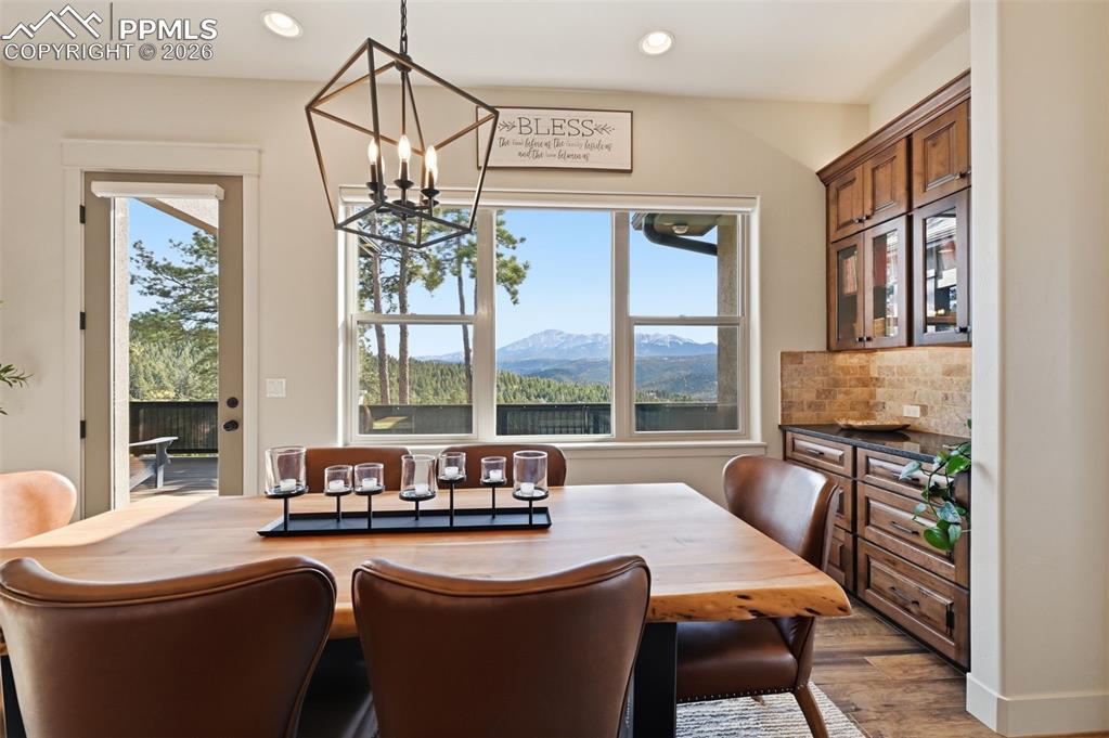 Dining space featuring suspended lighting, plenty of natural light, light wood-style floors, and a mountain view
