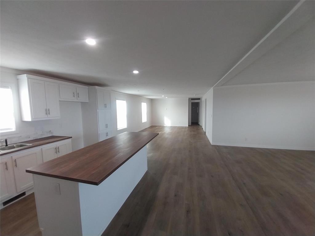 Kitchen with white cabinets, dark wood-style flooring, a center island, open floor plan, and recessed lighting