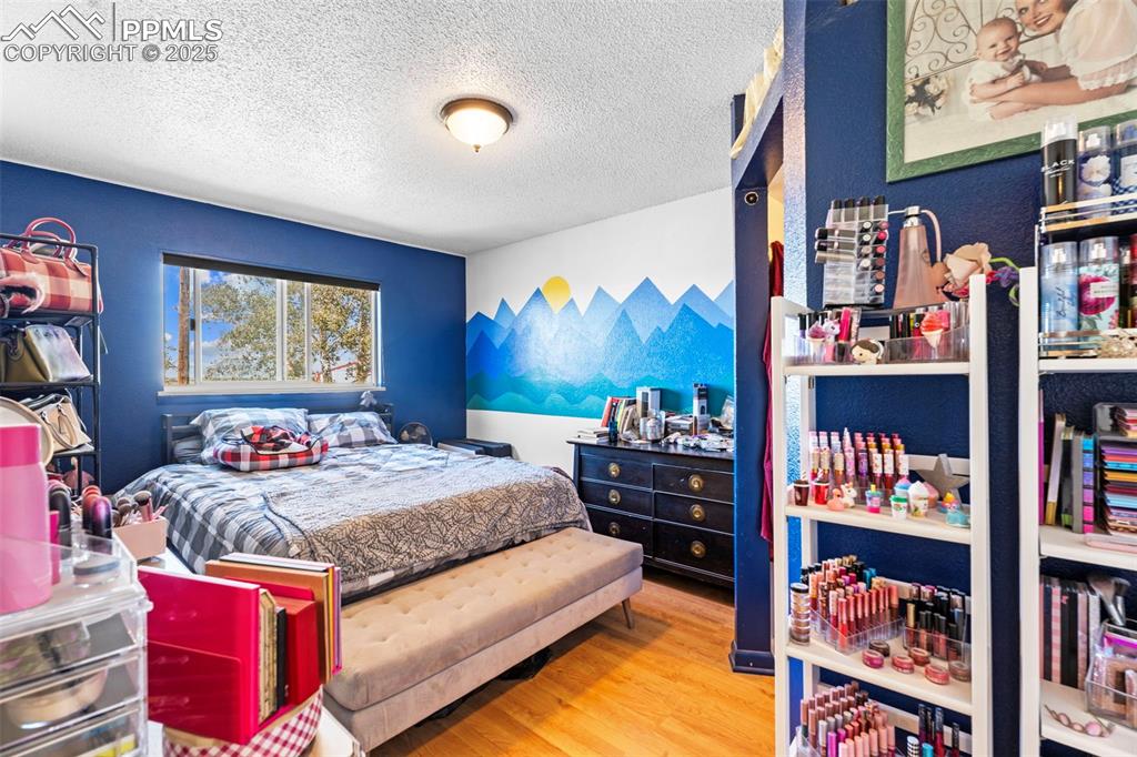 Bedroom featuring wood finished floors and a textured ceiling