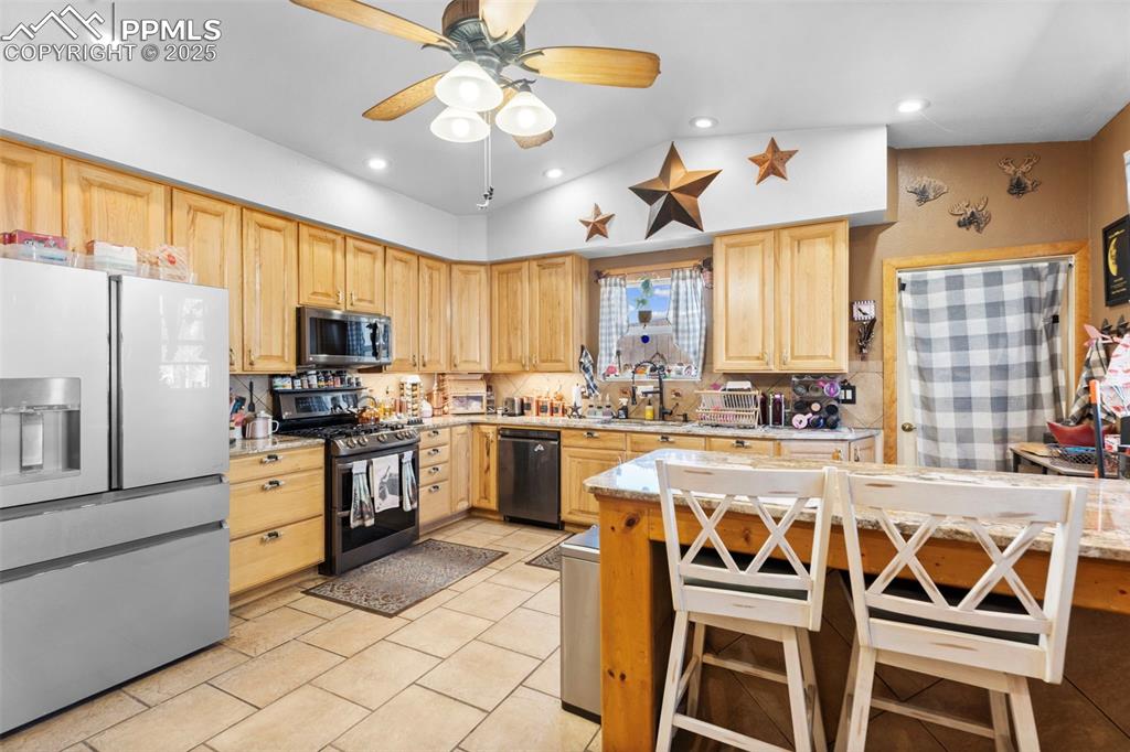 Kitchen featuring stainless steel appliances, light stone countertops, recessed lighting, tasteful backsplash, and light tile patterned floors