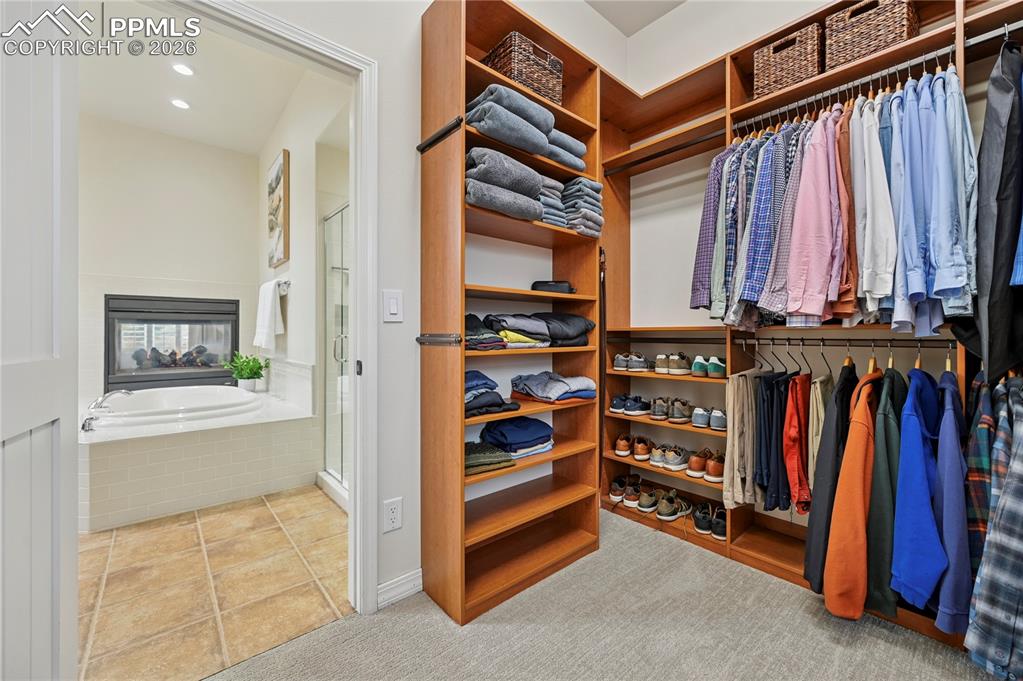 Walk in closet featuring light colored carpet and light tile patterned flooring