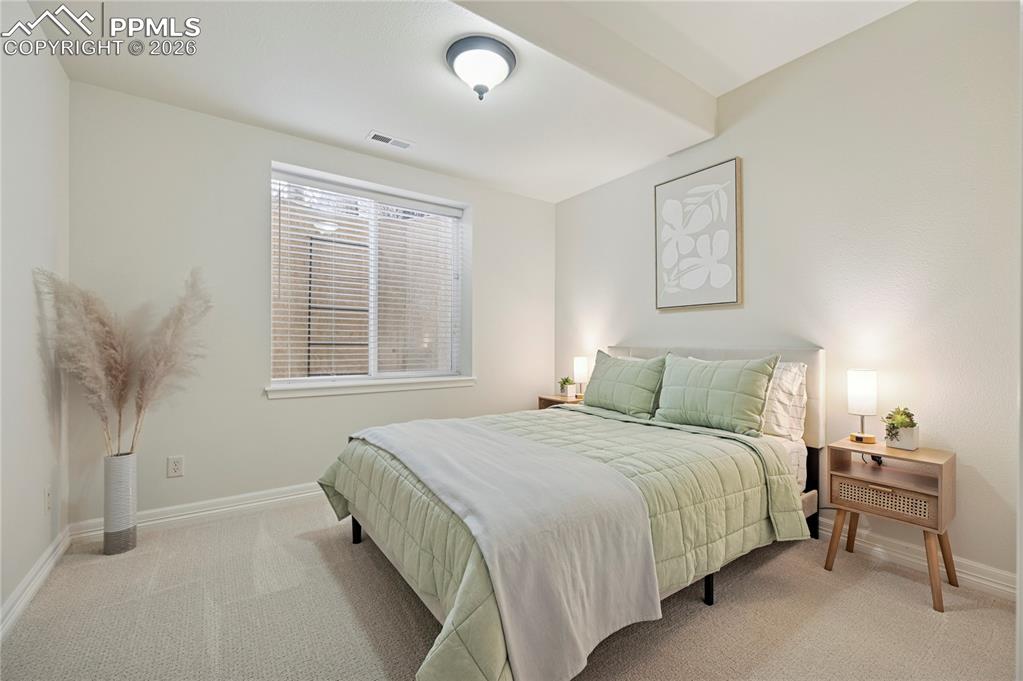 Bedroom featuring light carpet and baseboards
