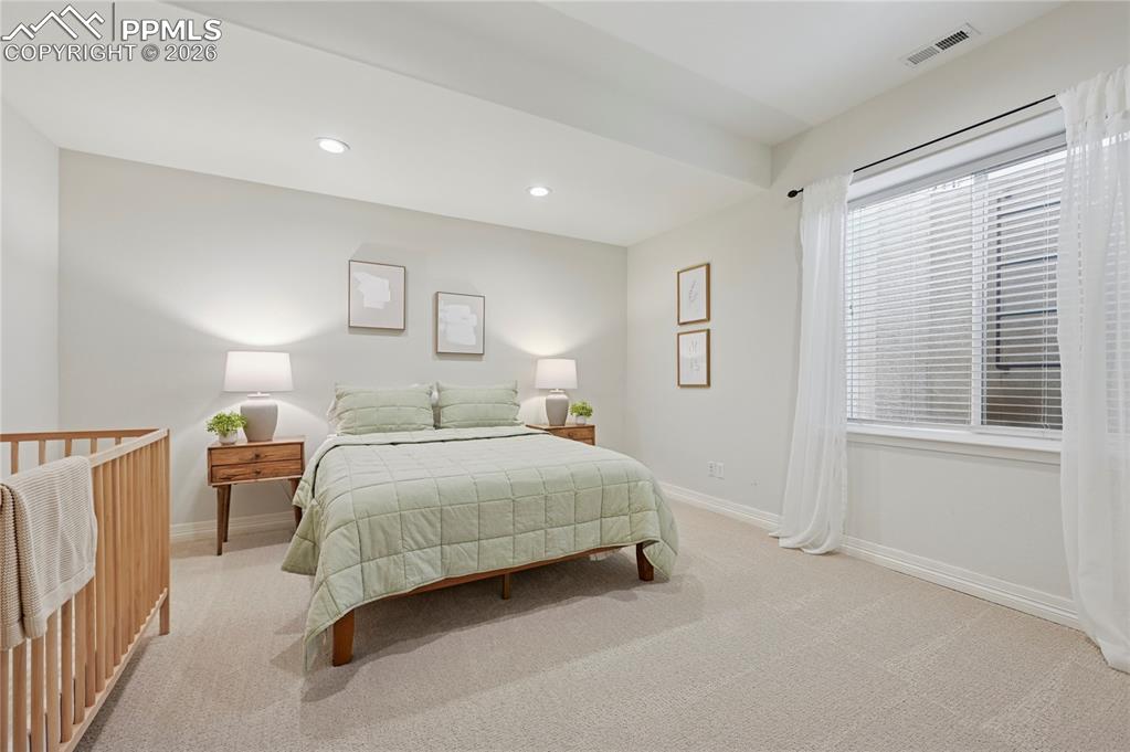 Bedroom with light carpet and recessed lighting