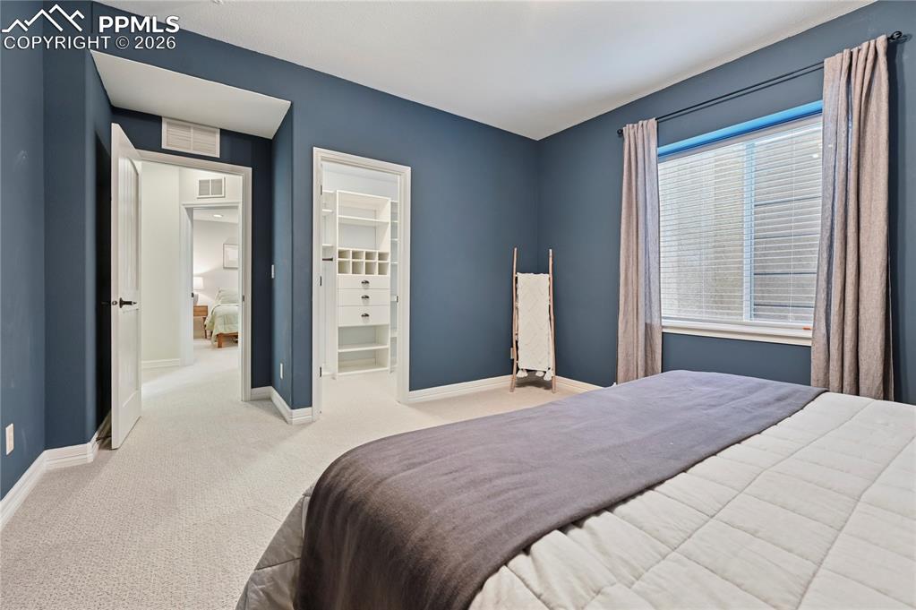 Bedroom with a walk in closet and carpet floors