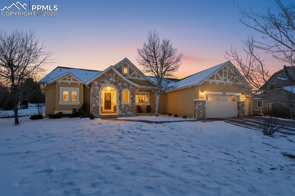 View of front of house with stone siding and an attached garage