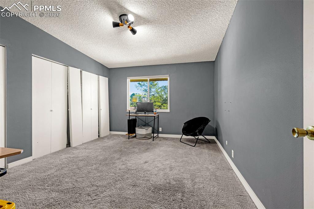 Office space with carpet floors and a textured ceiling
