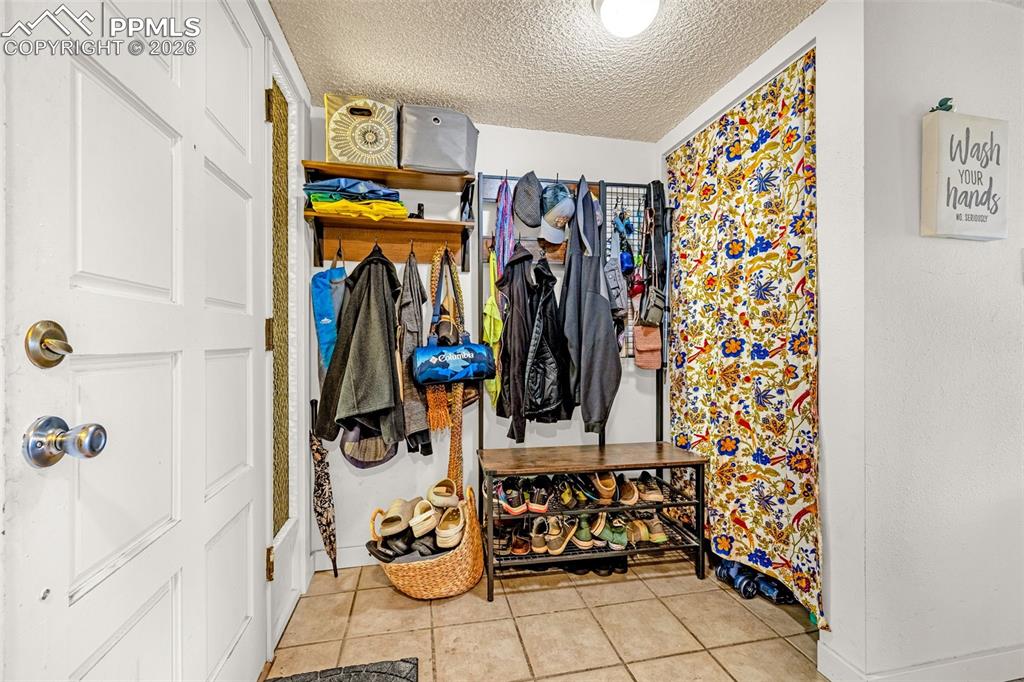 Mudroom featuring a textured ceiling and light tile patterned flooring