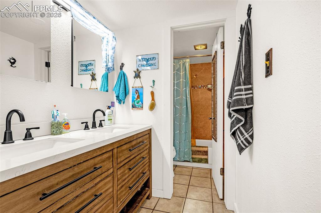 Bathroom with double vanity and light tile patterned flooring