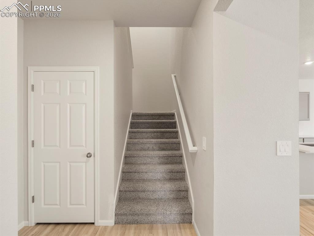 Staircase with wood finished floors and baseboards