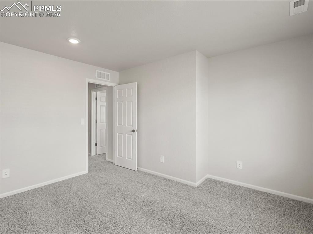 Carpeted empty room with baseboards and recessed lighting