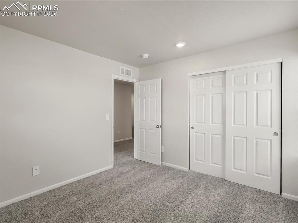 Unfurnished bedroom with carpet flooring, a closet, and recessed lighting