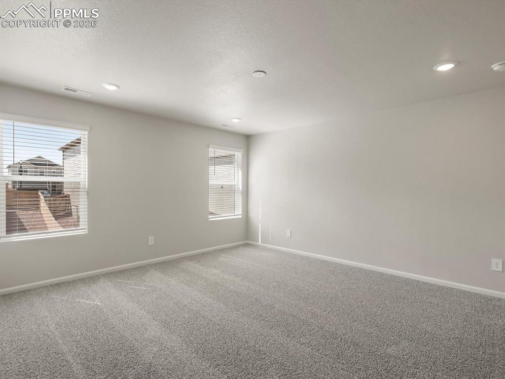 Carpeted empty room featuring recessed lighting and a textured ceiling
