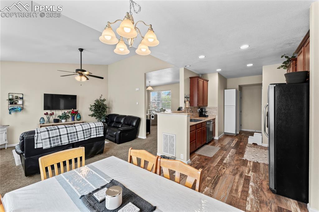 Dining space with a ceiling fan, recessed lighting, a chandelier, and dark wood-style flooring